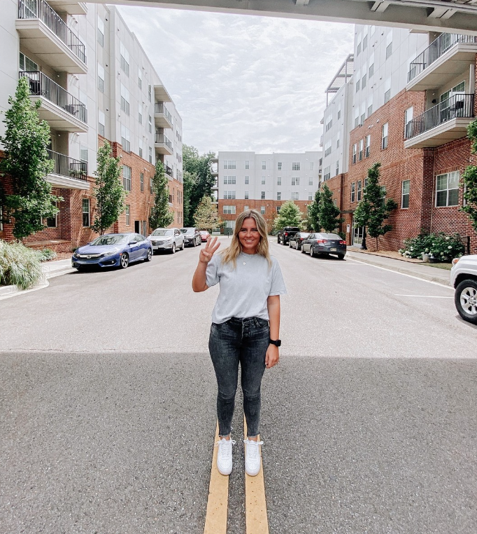 Sustainability Apartment Complex | Girl Standing in Parking Lot of Apartment Complex